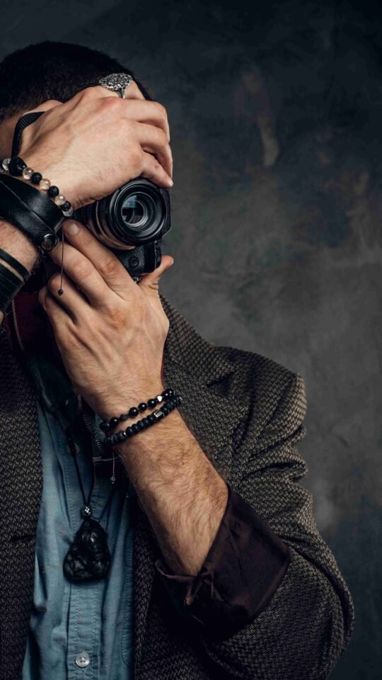 focused-young-photographer-is-taking-photo-dark-grunge-background_11zon